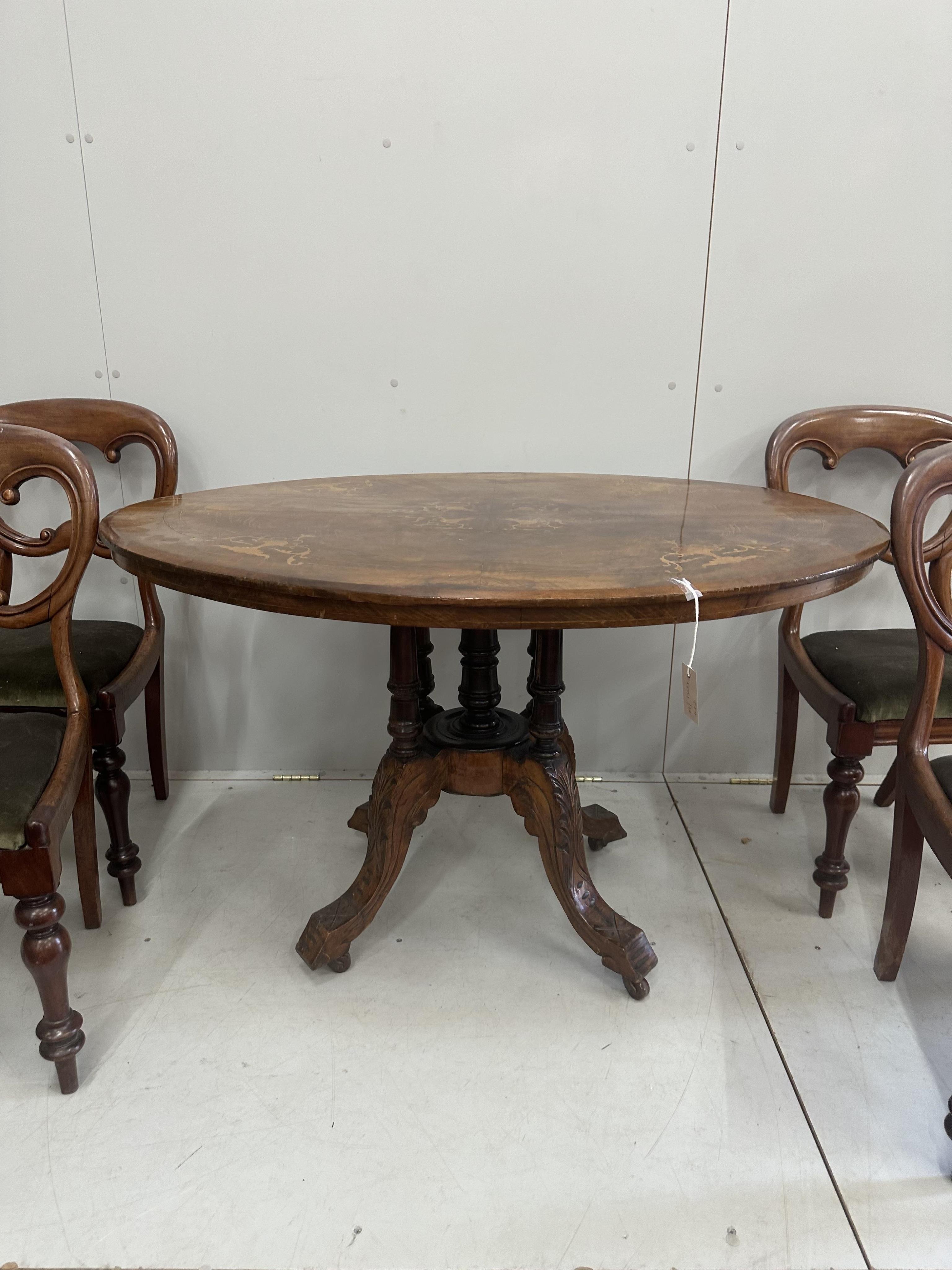 A Victorian inlaid walnut oval loo table, width 120cm, depth 86cm, height 72cm, lacks bolts together with four Victorian mahogany balloon back dining chairs. Condition - poor to fair